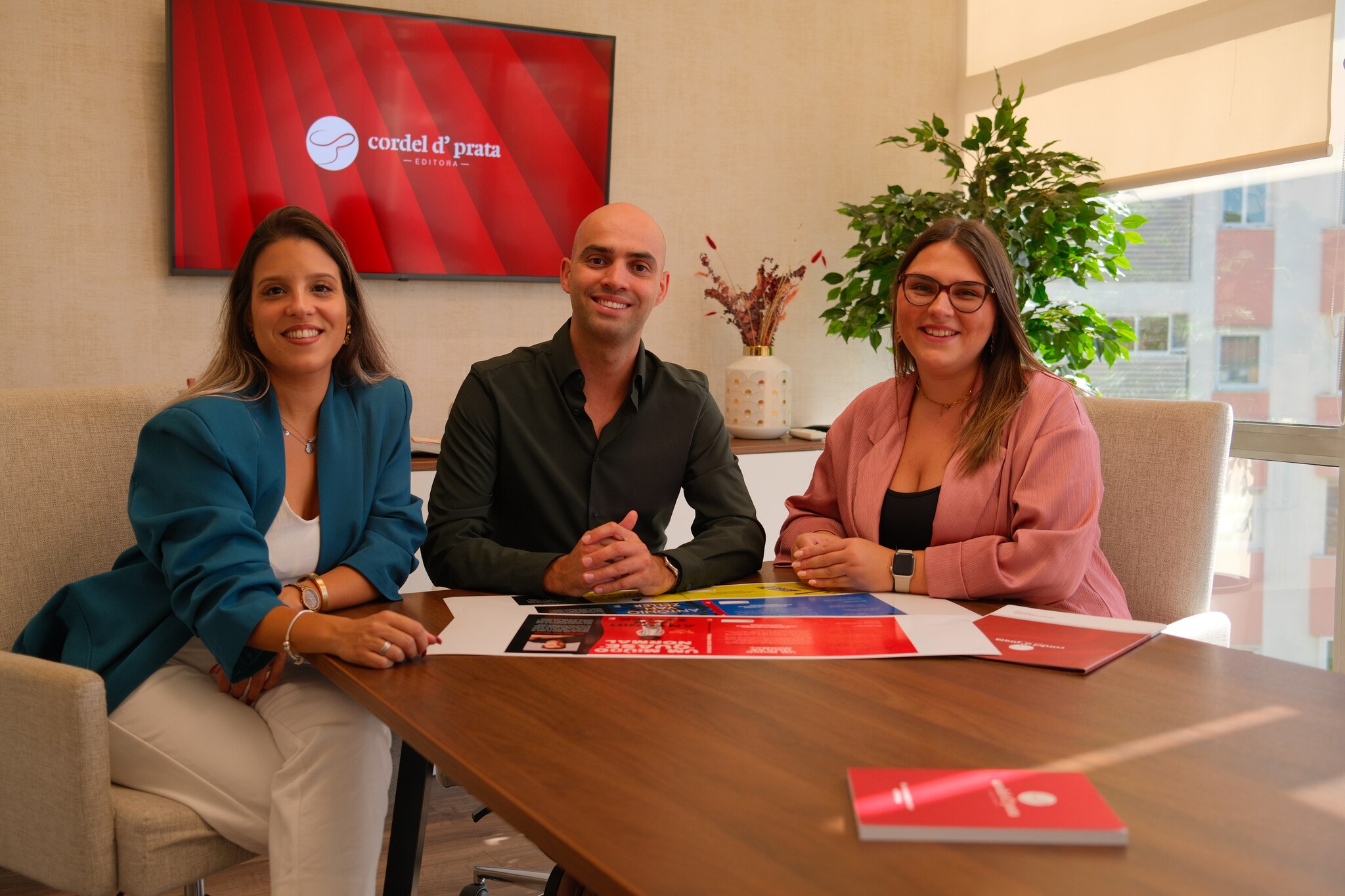 Reunião editorial à volta de uma mesa com livros