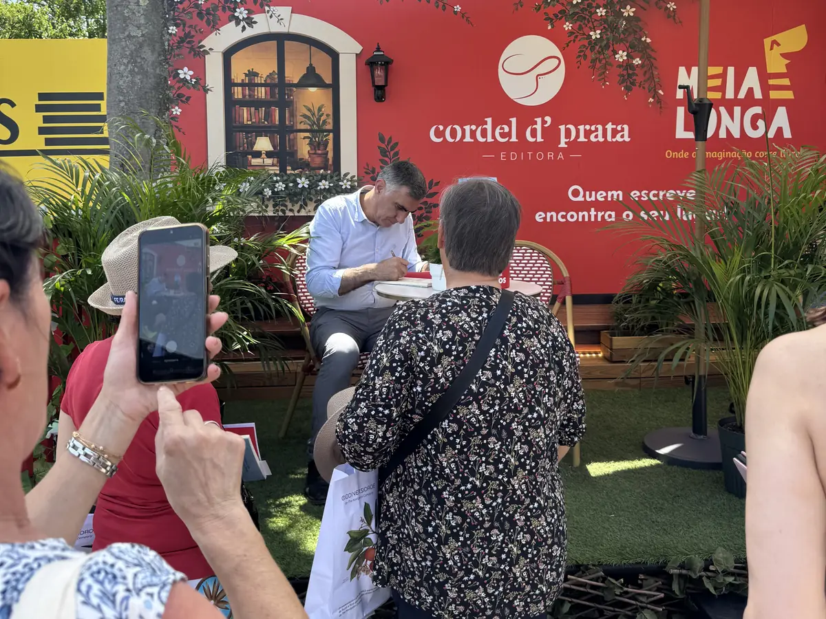 Autor a assinar livros na banca da Cordel D' Prata na Feira do Livro de Lisboa, com leitores à espera