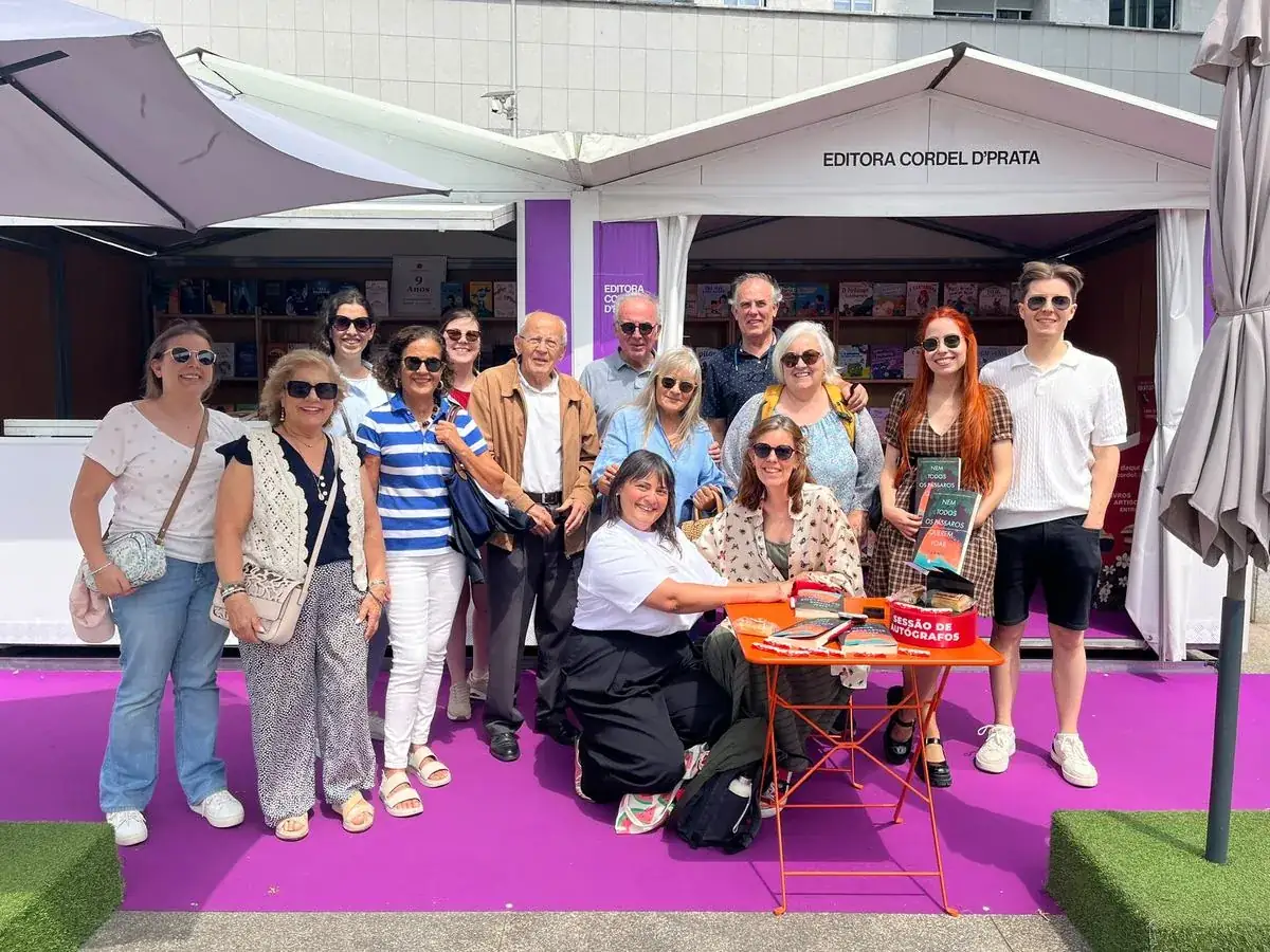 Grupo de leitores e autores à frente do stand da Cordel D' Prata na Feira do Livro da Maia, junto à mesa de autógrafos