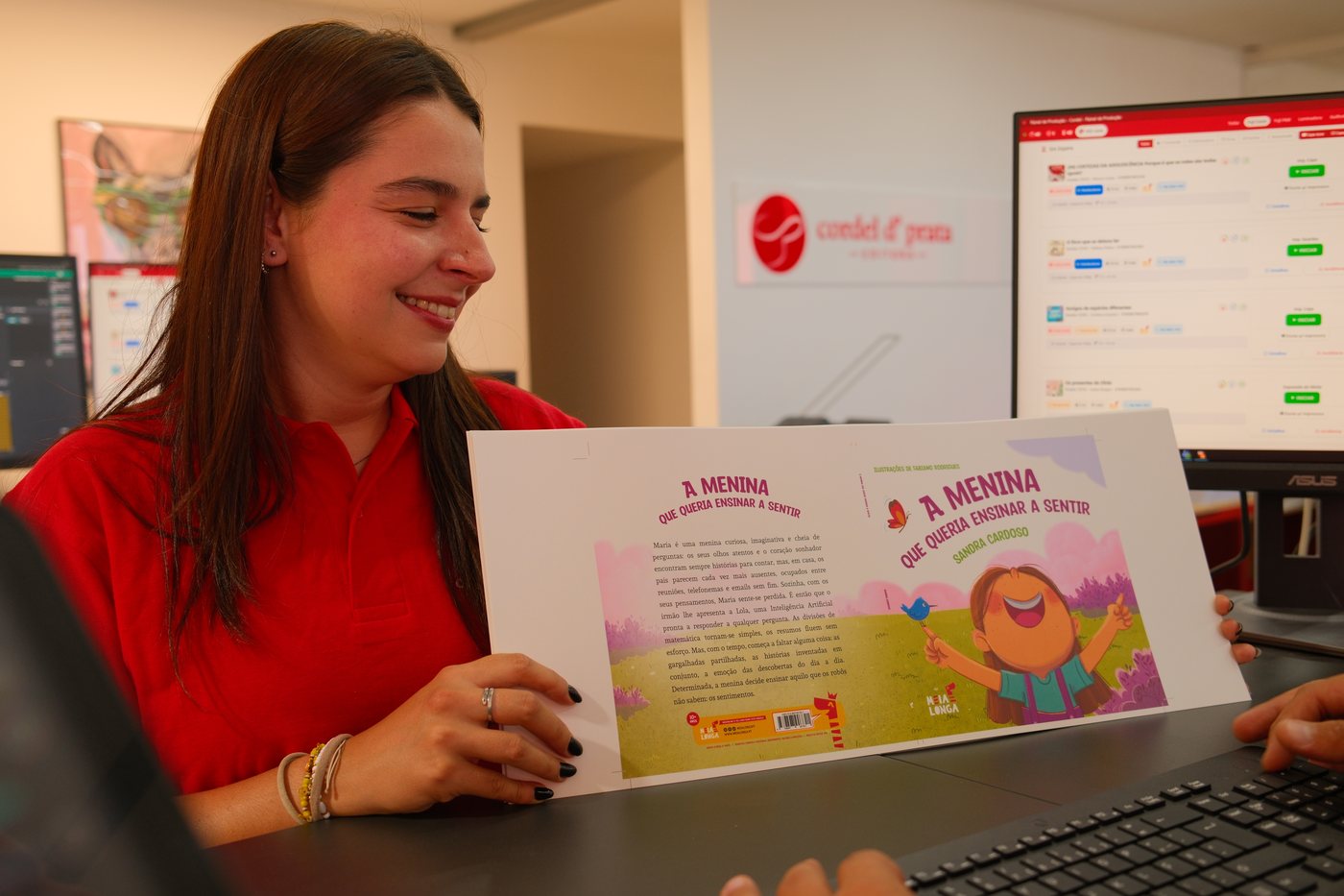 Elemento da equipa a conferir a prova da capa de um livro infantil