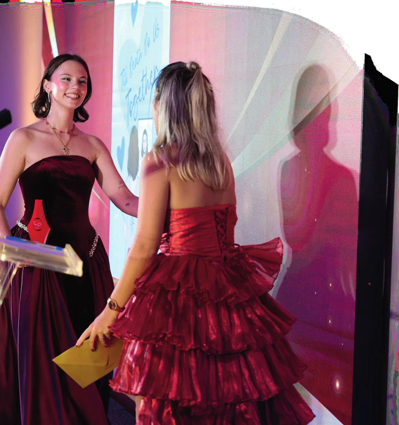 Lara Afonso, de vestido vermelho, no palco com o troféu